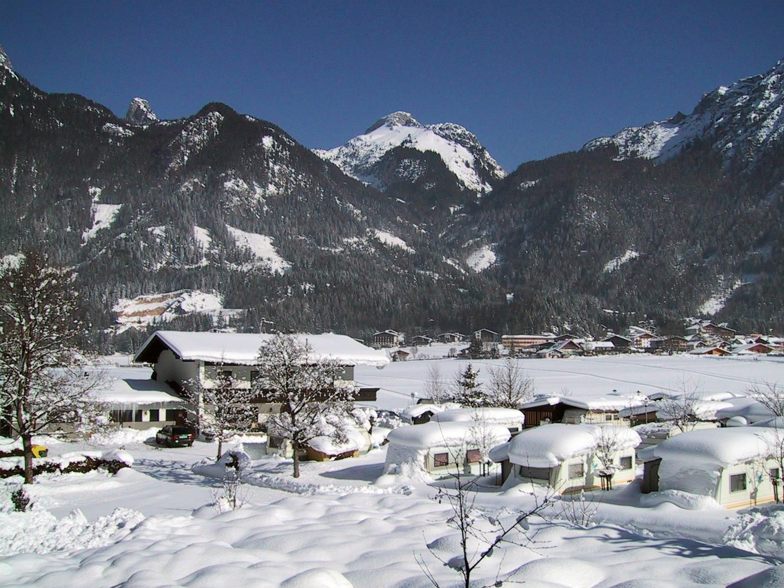 A picturesque winter landscape with snow-covered mountains and houses. The peaceful atmosphere invites you to relax.