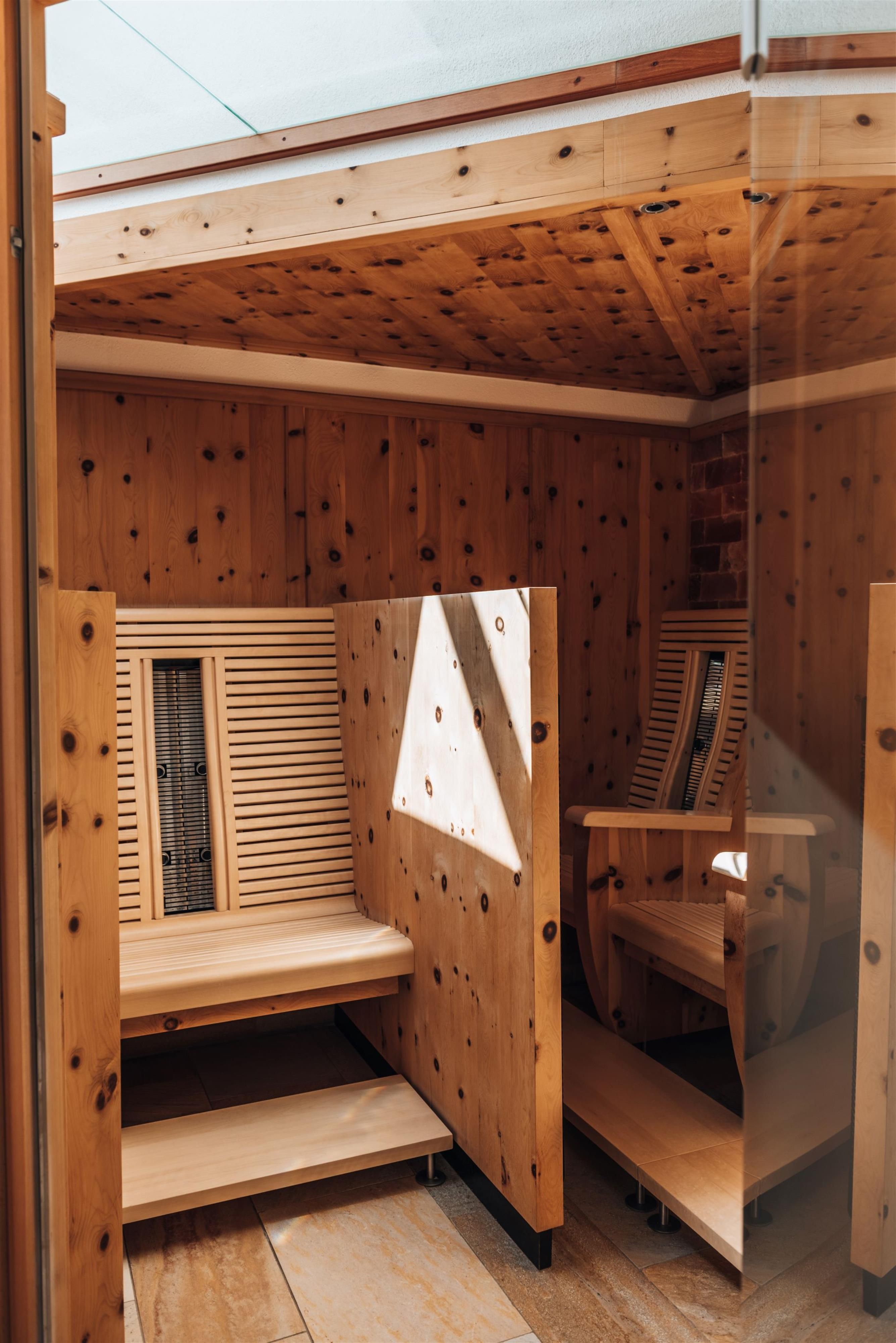 A cozy interior with a wooden sauna. The walls are made of wooden planks, and there are seating areas for relaxation.