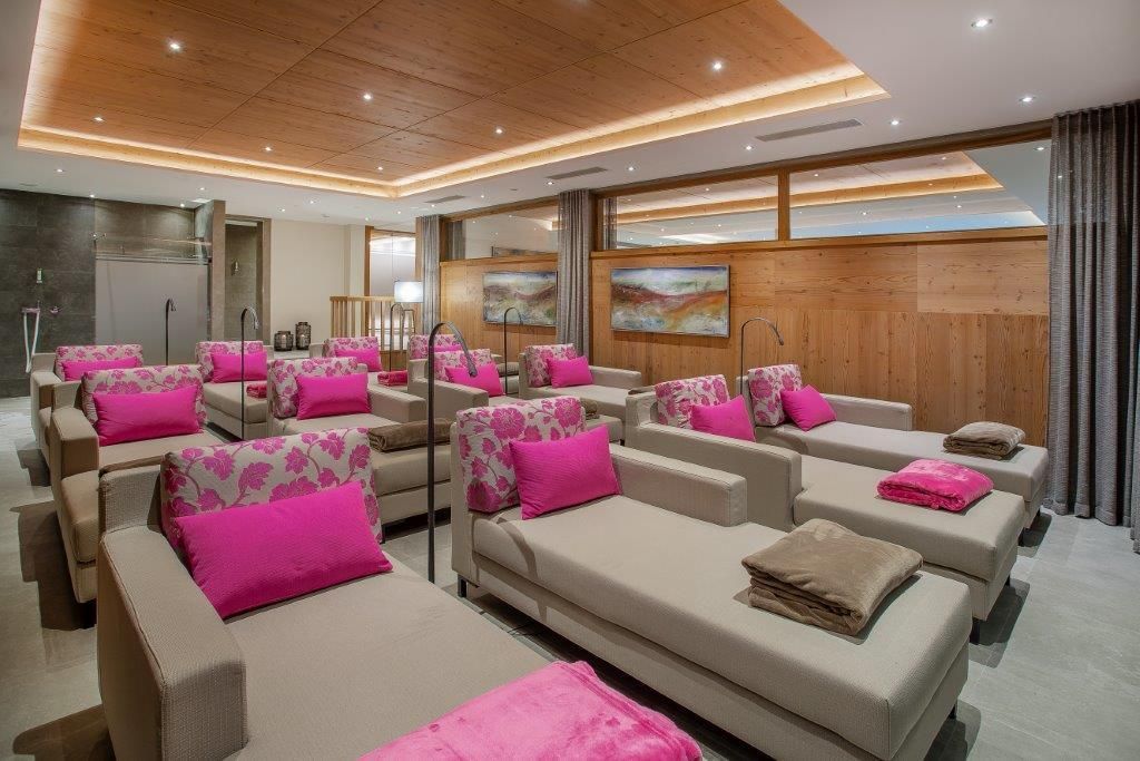 A stylish relaxation area with modern loungers and bright pink cushions. The warm wooden elements create an inviting and cozy atmosphere.