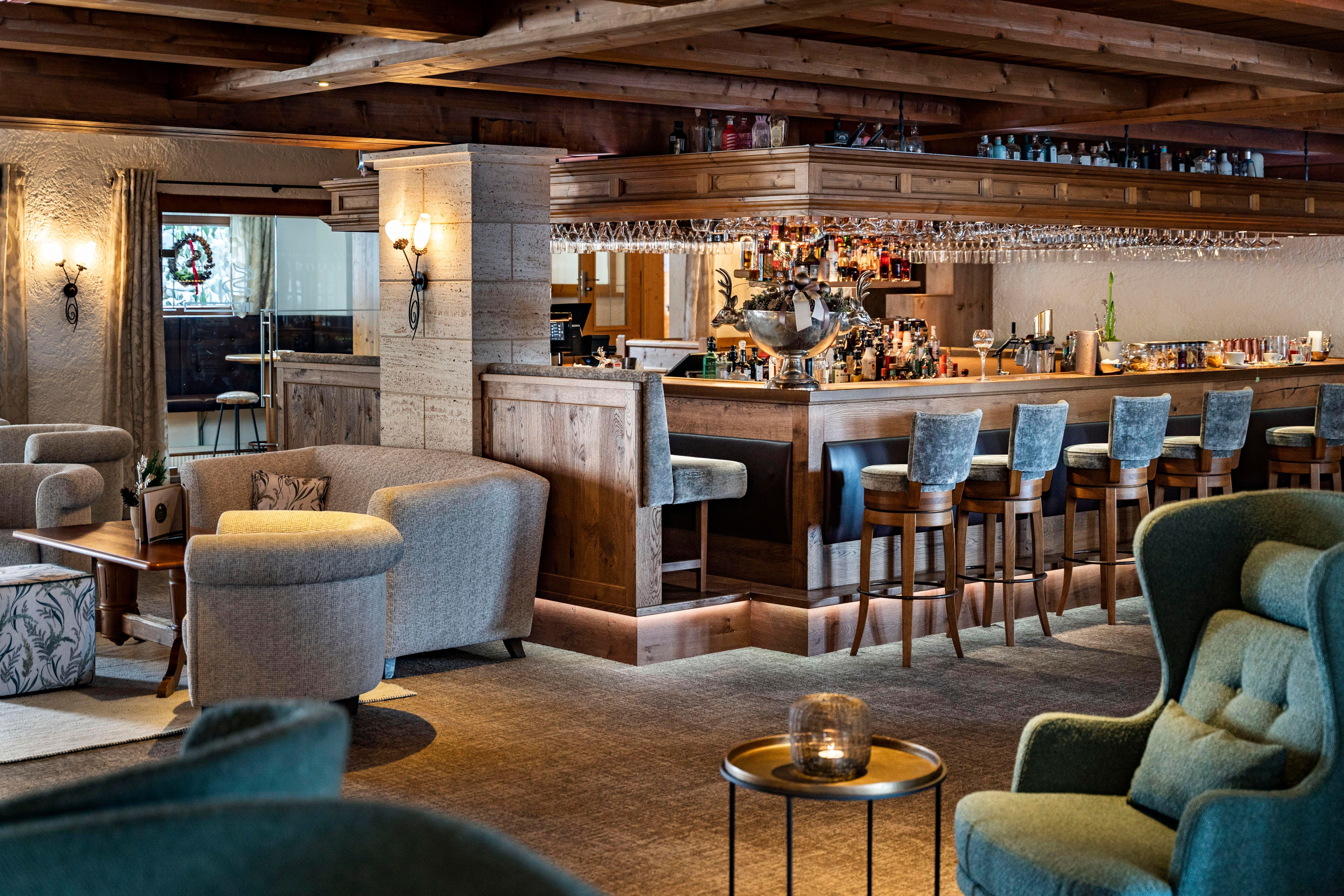 An elegant bar with wooden details and comfortable seating. The atmosphere is cozy and inviting.
