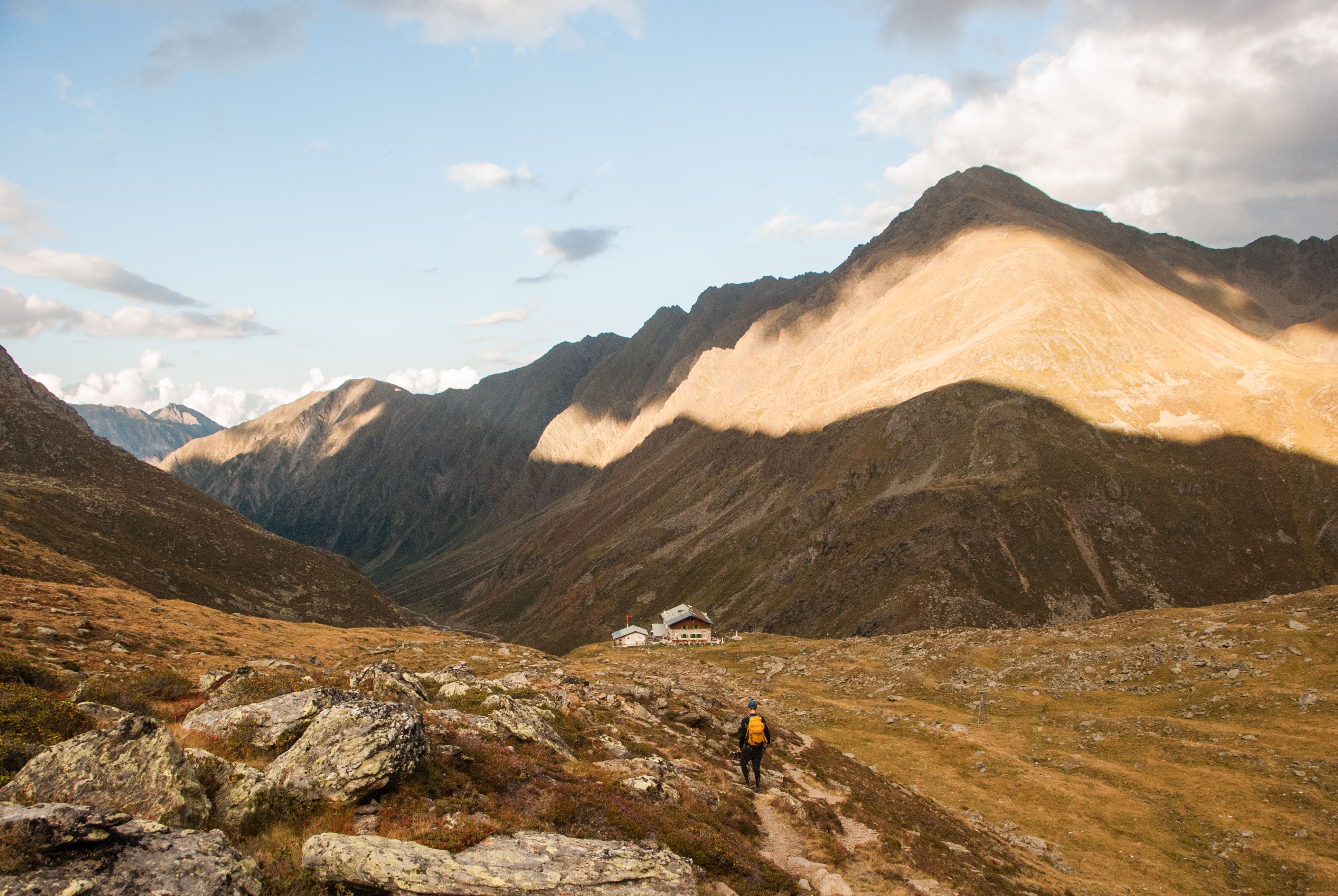 Pforzheimer Hütte auf der Sellrainer Hüttenrunde, Wanderer kommt bei der Hütte an, Abendstimmung in den Bergen