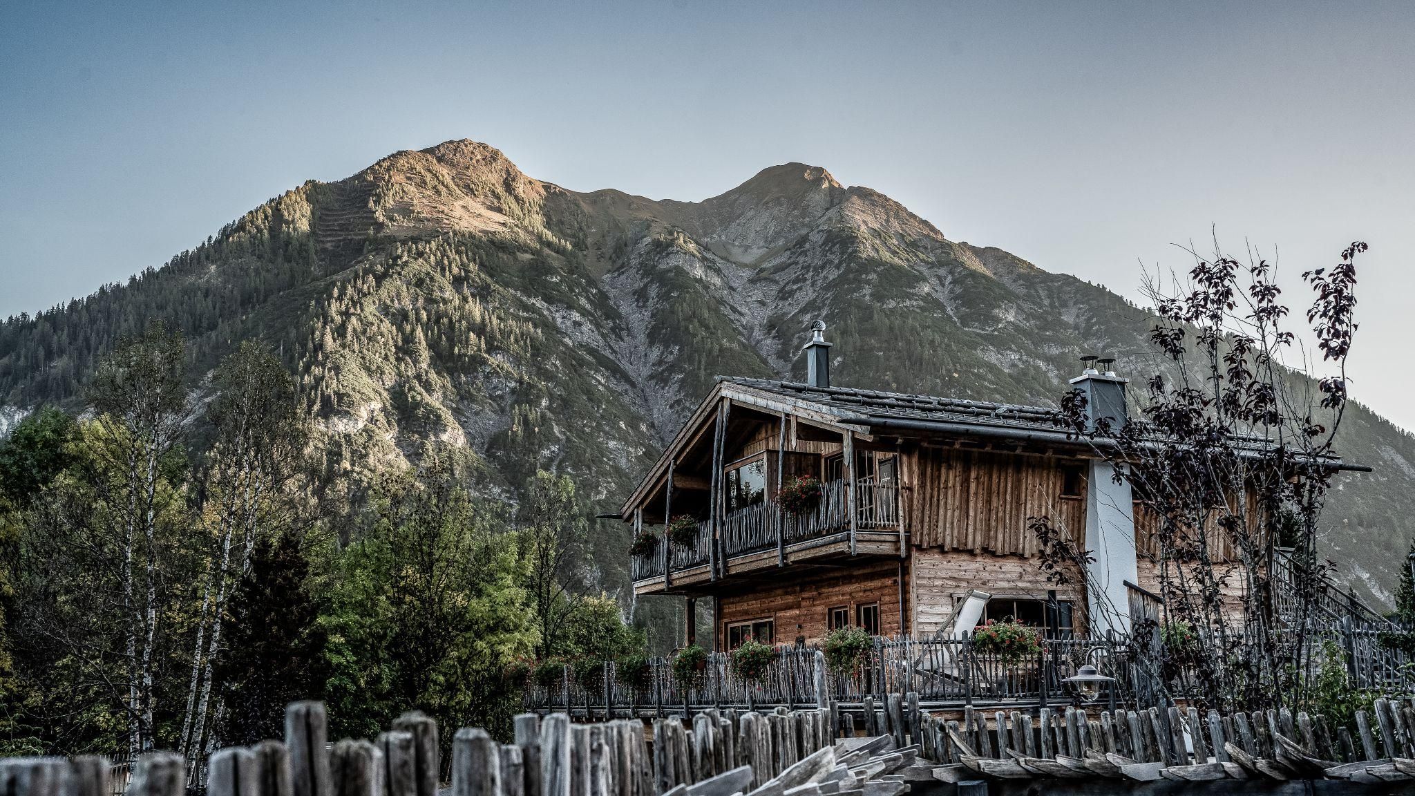 A charming chalet is nestled in the mountains. The majestic peaks surround the tranquil landscape.