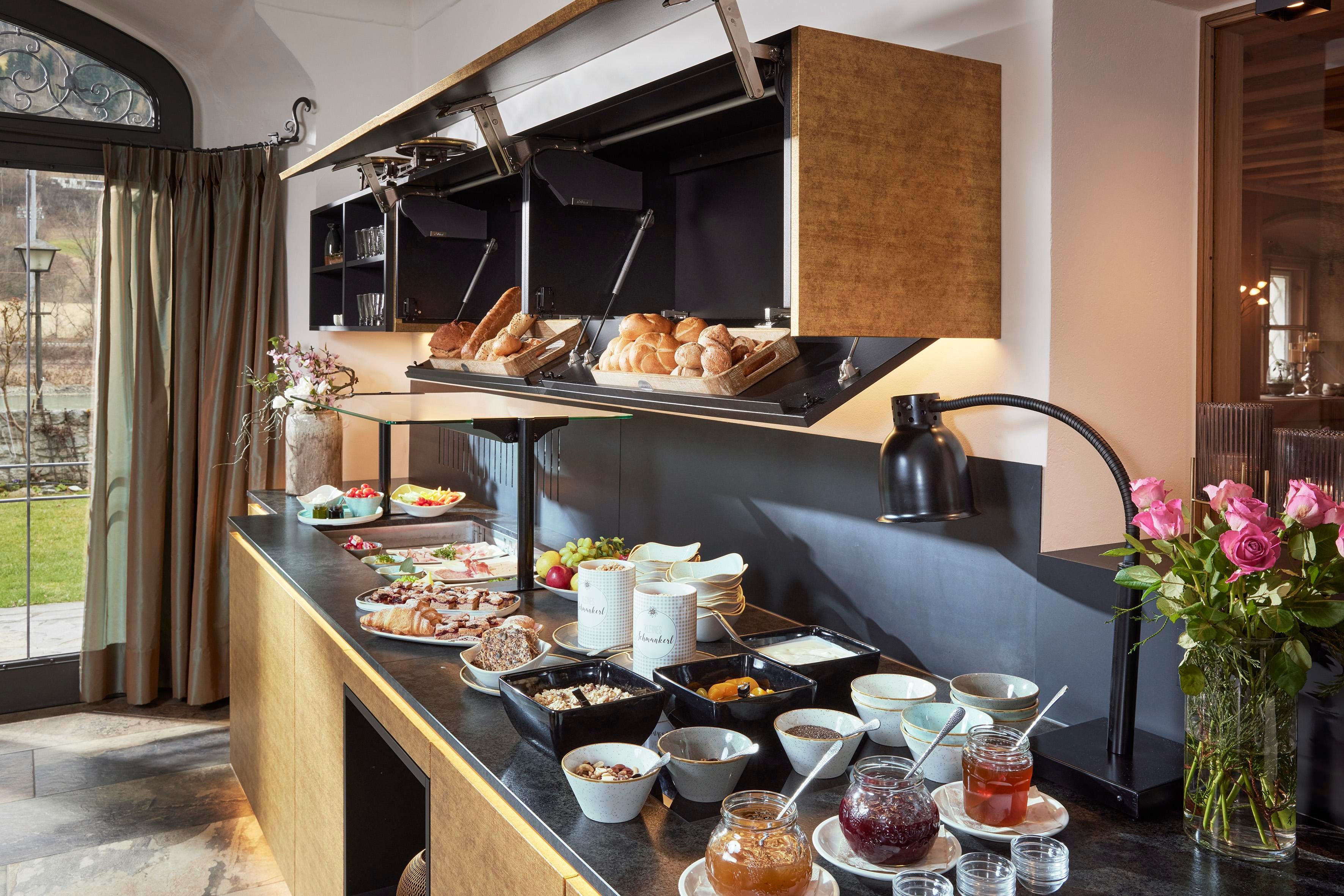 An elegant buffet with a selection of breakfast dishes. Fresh bread, fruit, and various spreads are attractively arranged.