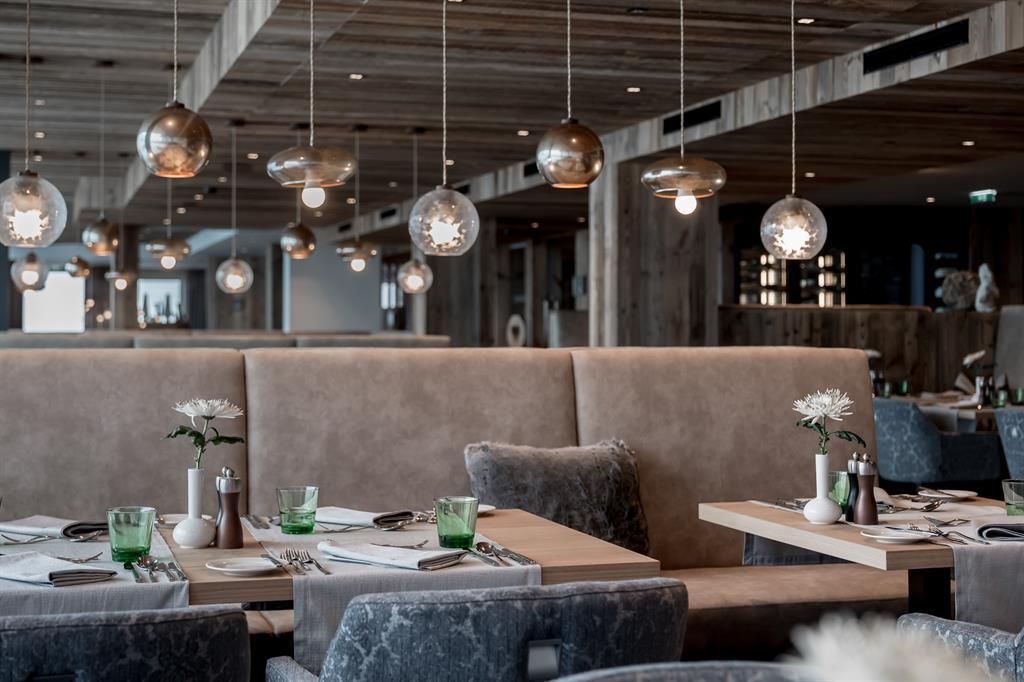 A modern restaurant with elegant tables and stylish lighting. The atmosphere is cozy and inviting.