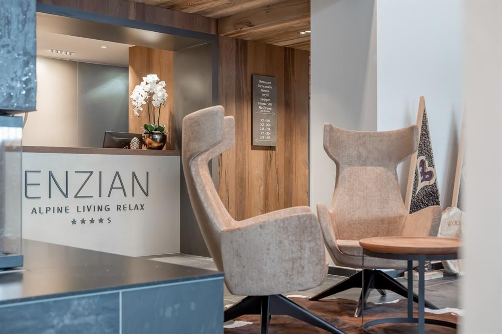 An elegant hotel lobby with a reception desk and modern, comfortable armchairs. The atmosphere is friendly and inviting, perfect for relaxing.