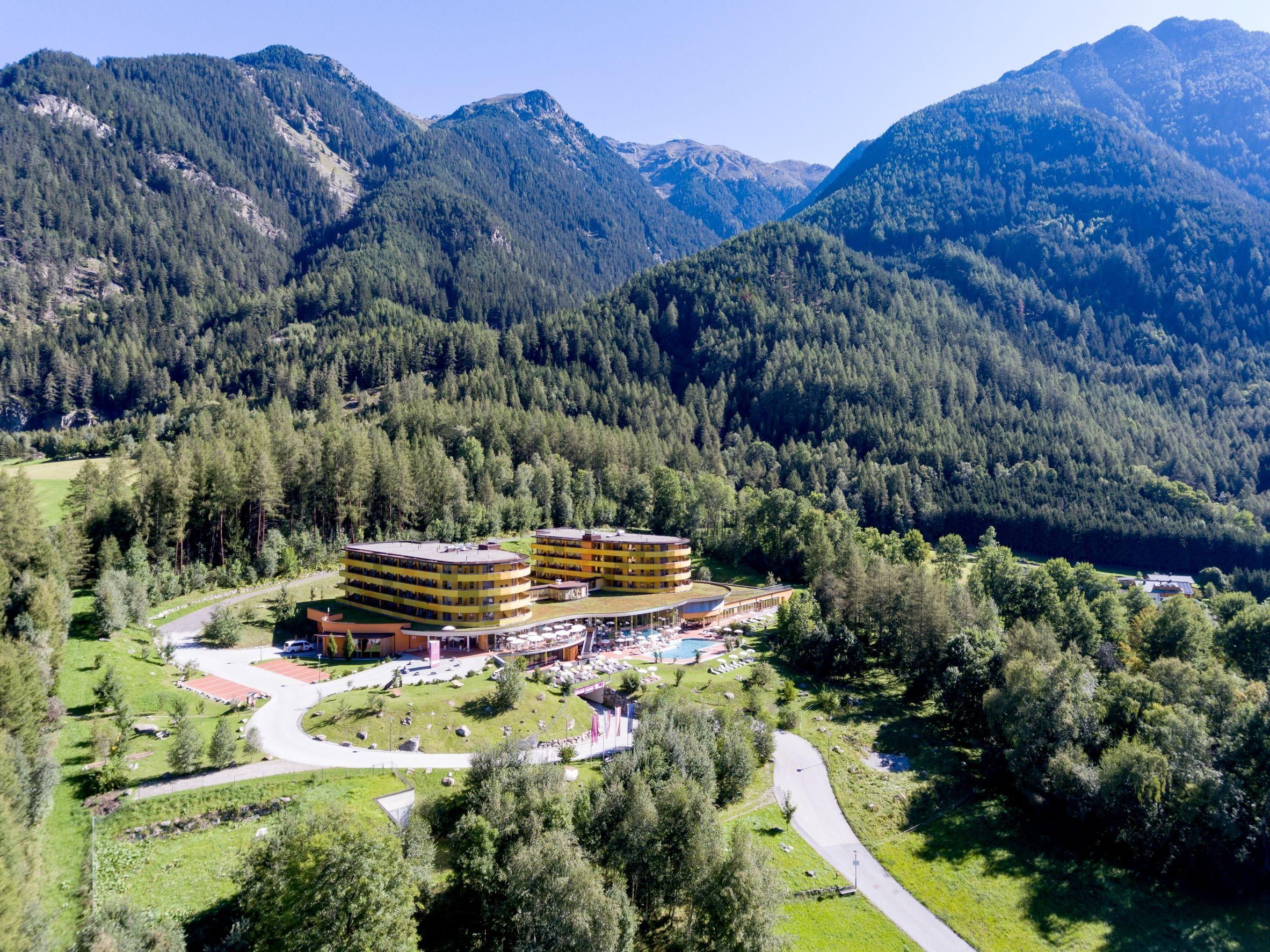 A modern hotel amidst high mountains and dense forests. The surroundings are nature-friendly and inviting.