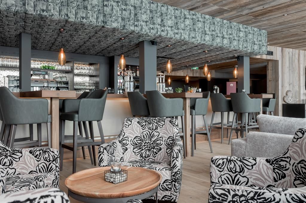 A modern restaurant with a stylish bar. The décor is elegant with comfortable chairs and tables.